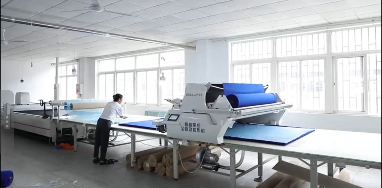 Fabric being prepared on the spreading machine before garment panels are cut